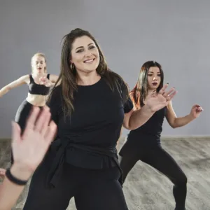 Trainerin leitet einen Fitnesskurs mit mehreren Teilnehmerinnen